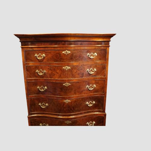 fig 6. A tall George V walnut serpentine front tallboy chest featuring multiple drawers with decorative brass drop handles.