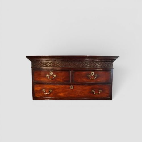 fig 3. A tall George III mahogany chest-on-chest featuring a carved blind fretwork cornice, brass swan-neck handles, and bracket feet.