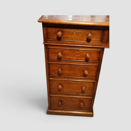 fig 2. A Victorian mahogany partners desk featuring a tooled leather writing surface, twin pedestals, and an eleven-drawer front configuration with turned wooden knobs.