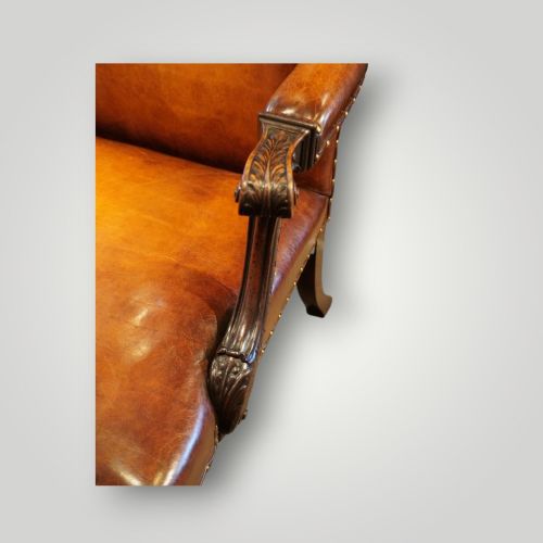 fig 3. A Georgian style Gainsborough armchair upholstered in warm tan leather with brass stud detailing and carved mahogany legs.