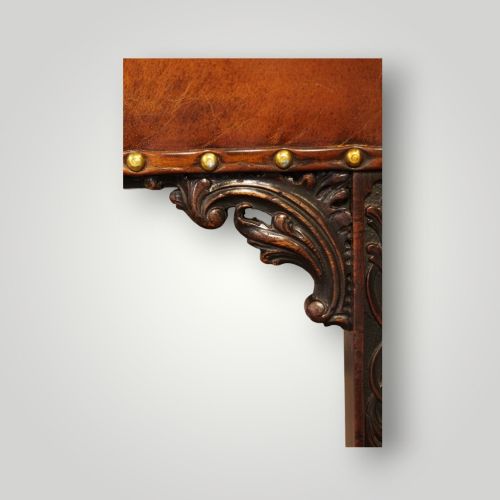 fig 6. A Georgian style Gainsborough armchair upholstered in warm tan leather with brass stud detailing and carved mahogany legs.