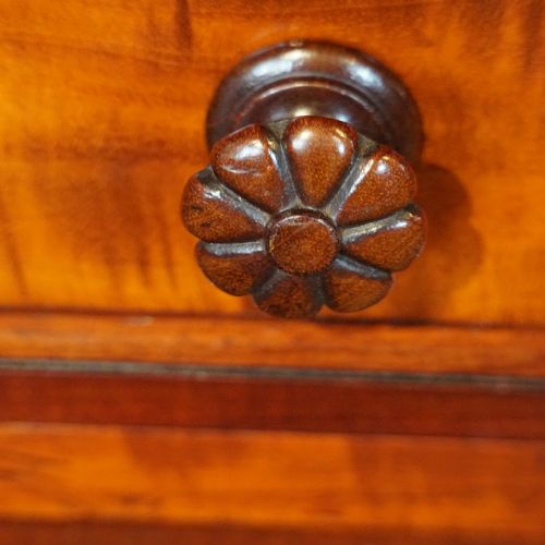 fig 8. Victorian mahogany writing table featuring a dark green leather top, five drawers with circular wooden handles, turned legs, and brass castors.