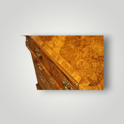 fig 2. A George I walnut bureau bookcase featuring glazed upper doors housing books, a slant-front writing flap, and lower drawers with brass drop handles.