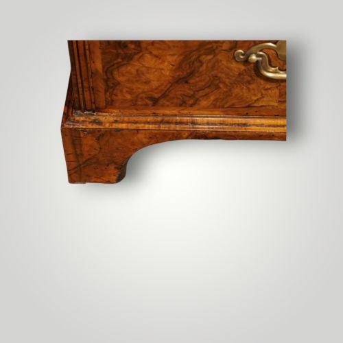 fig 7. A George I walnut bureau bookcase featuring glazed upper doors housing books, a slant-front writing flap, and lower drawers with brass drop handles.