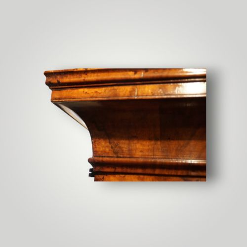 fig 9. A George I walnut bureau bookcase featuring glazed upper doors housing books, a slant-front writing flap, and lower drawers with brass drop handles.