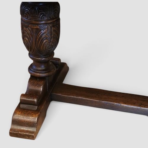fig 1. A rectangular solid oak refectory dining table featuring turned bulbous pedestal supports connected by a low central stretcher rail.