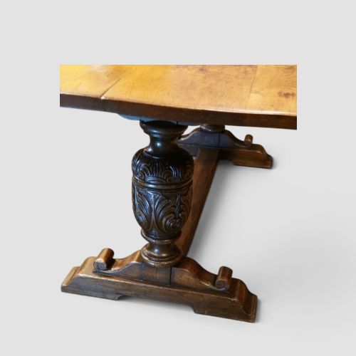 fig 4. A rectangular solid oak refectory dining table featuring turned bulbous pedestal supports connected by a low central stretcher rail.