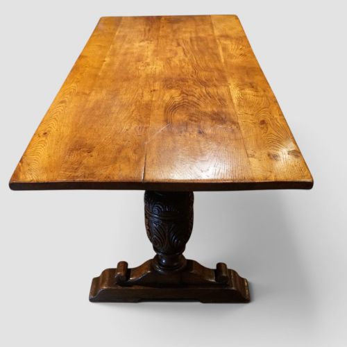 fig 5. A rectangular solid oak refectory dining table featuring turned bulbous pedestal supports connected by a low central stretcher rail.