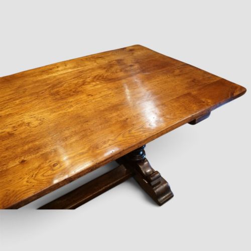 fig 8. A rectangular solid oak refectory dining table featuring turned bulbous pedestal supports connected by a low central stretcher rail.