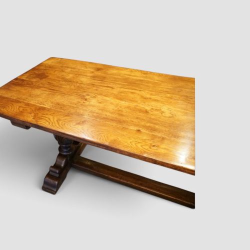 fig 9. A rectangular solid oak refectory dining table featuring turned bulbous pedestal supports connected by a low central stretcher rail.