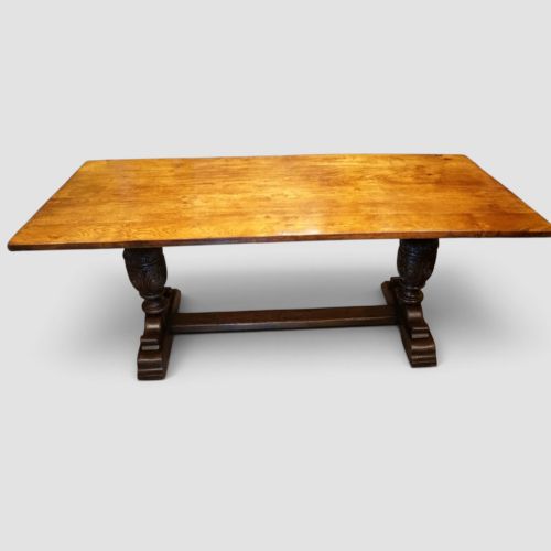 fig 10. A rectangular solid oak refectory dining table featuring turned bulbous pedestal supports connected by a low central stretcher rail.
