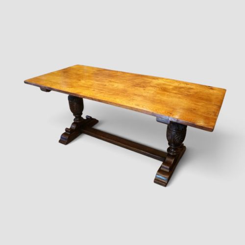 fig 11. A rectangular solid oak refectory dining table featuring turned bulbous pedestal supports connected by a low central stretcher rail.