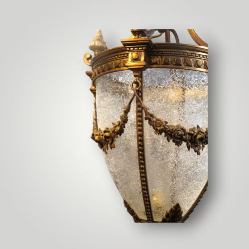 fig 3. A nineteenth-century gilt bronze hall lantern featuring a tapered glass vessel, acanthus leaf canopy, and decorative drapery swags.