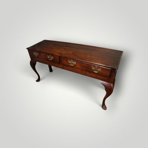 fig 1. A Georgian oak dresser base featuring two wide drawers with decorative brass handles and four cabriole legs with pad feet.