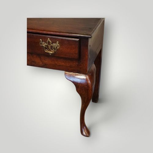 fig 3. A Georgian oak dresser base featuring two wide drawers with decorative brass handles and four cabriole legs with pad feet.