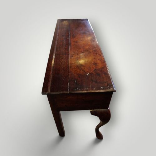 fig 5. A Georgian oak dresser base featuring two wide drawers with decorative brass handles and four cabriole legs with pad feet.