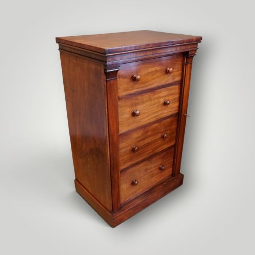 fig 1. A Victorian warm brown mahogany Wellington chest featuring four stacked drawers with turned wooden handles and a side locking bar.