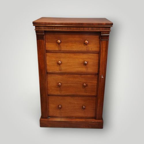 fig 4. A Victorian warm brown mahogany Wellington chest featuring four stacked drawers with turned wooden handles and a side locking bar.