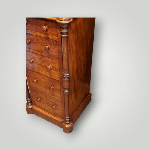 fig 1. A matching pair of narrow Victorian mahogany bedside chests featuring five graduated drawers with turned side columns on plinth bases.