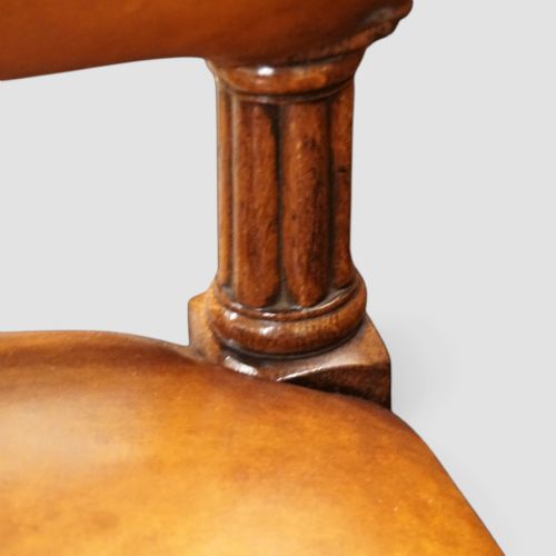 fig 5. A set of four Victorian oak dining chairs featuring arched gothic-style backrests upholstered in warm brown leather with brass stud trim.