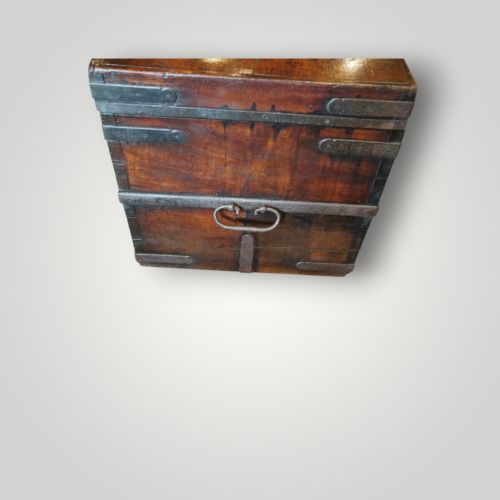fig 2. A rectangular antique walnut wood trunk featuring heavy iron binding straps, metal corner hardware, and a brass plaque on the lid.