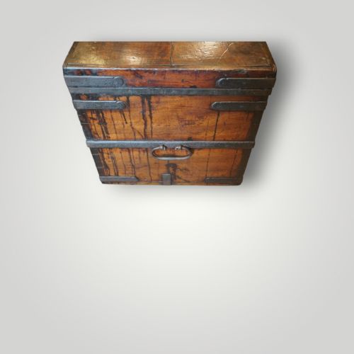 fig 3. A rectangular antique walnut wood trunk featuring heavy iron binding straps, metal corner hardware, and a brass plaque on the lid.