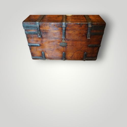 fig 4. A rectangular antique walnut wood trunk featuring heavy iron binding straps, metal corner hardware, and a brass plaque on the lid.