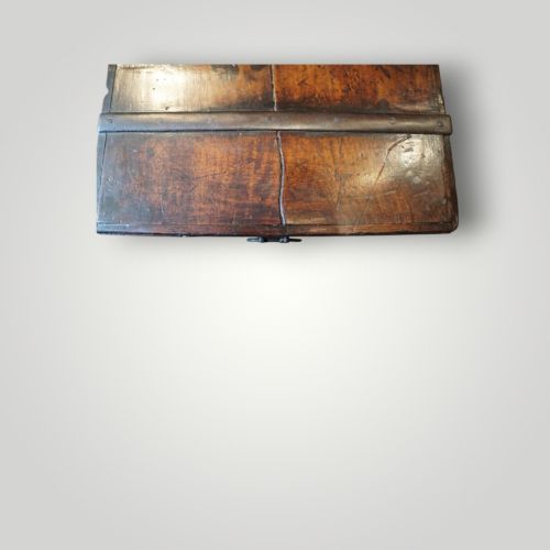 fig 9. A rectangular antique walnut wood trunk featuring heavy iron binding straps, metal corner hardware, and a brass plaque on the lid.