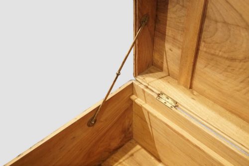 fig 2. A rectangular Victorian camphor wood campaign chest featuring polished brass binding along the edges, geometric dark line inlay, and a central brass lock escutcheon.