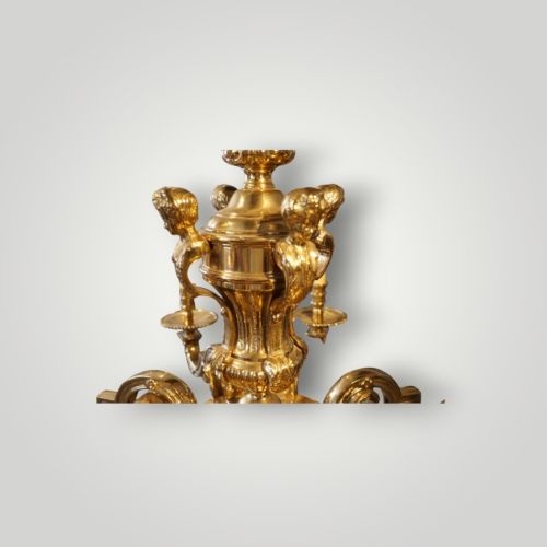 fig 6. A nineteenth-century French gilt bronze eight-light chandelier featuring a central urn column and scrolling candle arms with faux candle sleeves.
