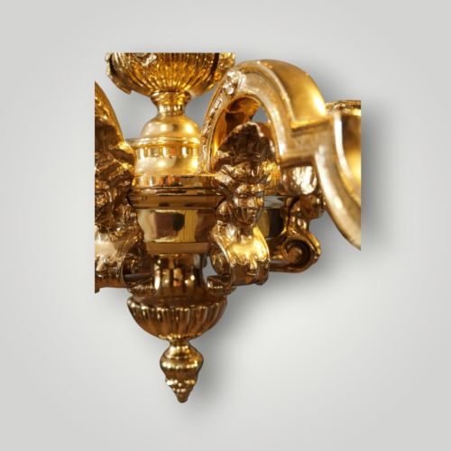 fig 7. A nineteenth-century French gilt bronze eight-light chandelier featuring a central urn column and scrolling candle arms with faux candle sleeves.