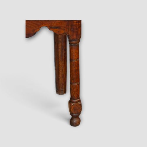 fig 6. An 18th-century George III dark oak dresser base featuring three drawers with brass handles and a scalloped apron on turned legs.