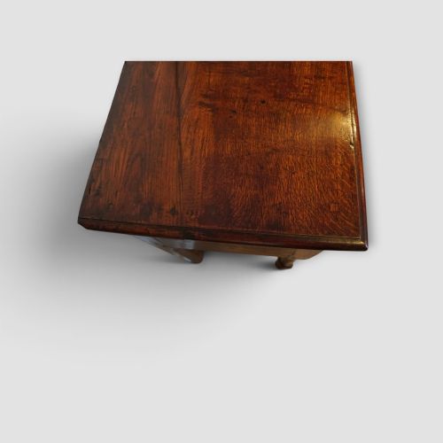 fig 7. An 18th-century George III dark oak dresser base featuring three drawers with brass handles and a scalloped apron on turned legs.