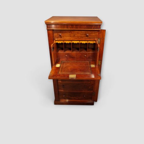 fig 4. A tall Victorian mahogany Wellington chest featuring seven drawer fronts, turned wooden knobs, and a right-hand side locking flap.