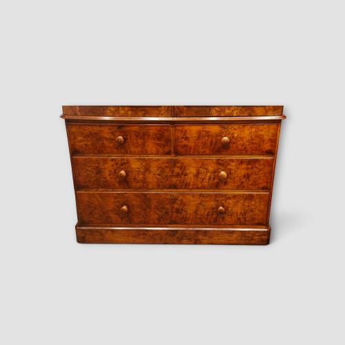 fig 1. A 19th-century Victorian burr walnut linen press featuring an upper cabinet with arched panel doors over a chest of four drawers with turned wooden knobs.