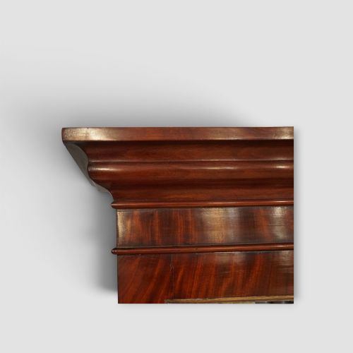 fig 5. A 19th-century mahogany breakfront bookcase featuring glazed upper doors filled with books above solid panelled cupboard doors.