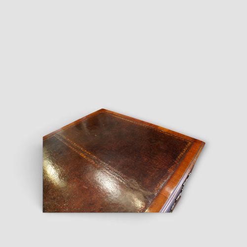 fig 5. A large Victorian mahogany partners desk featuring a brown leather inset writing surface, twin drawer pedestals, brass swan-neck handles, and a wide central kneehole.