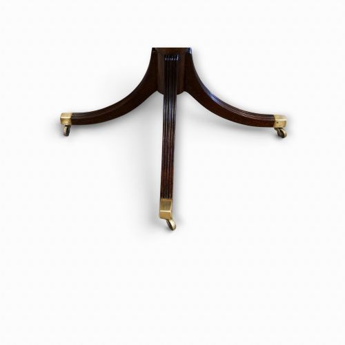 fig 5. A Georgian style dark mahogany dining table featuring an extendable top, twin turned pedestal pillars, and splayed quadruped legs with brass toe caps.