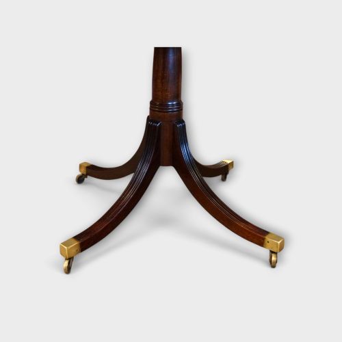fig 7. A Georgian style dark mahogany dining table featuring an extendable top, twin turned pedestal pillars, and splayed quadruped legs with brass toe caps.