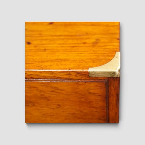 fig 2. A Victorian teak two-part military campaign chest of drawers featuring flush brass handles, brass corner mounts, and turned feet.