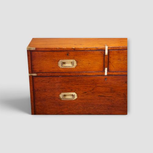 fig 3. A Victorian teak two-part military campaign chest of drawers featuring flush brass handles, brass corner mounts, and turned feet.