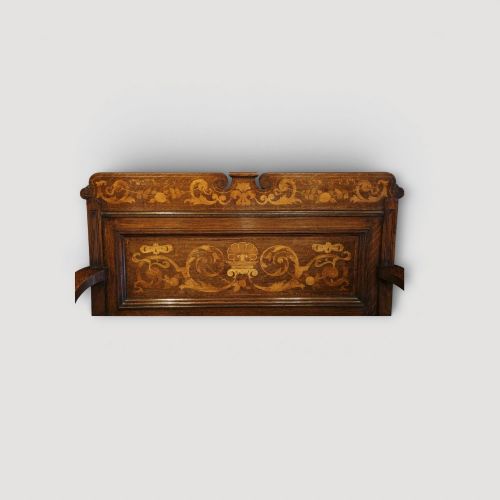 fig 3. An Art Nouveau solid oak settle featuring decorative marquetry inlay across the backrest and lower front panels, curved armrests, and a lift-up storage seat.