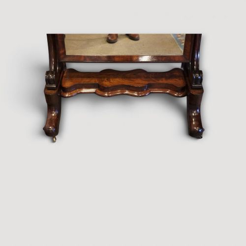 fig 7. A Victorian mahogany cheval mirror with a rectangular rounded tilting glass frame, dual upright supports, and a curved plinth base set on scroll legs.