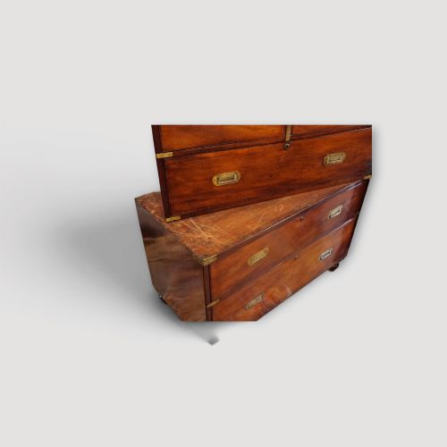 fig 5. A Victorian mahogany campaign chest featuring two short drawers over three long drawers with flush brass handles, brass corner brackets, and turned feet.