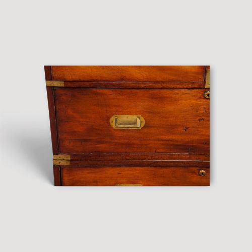 fig 6. A Victorian mahogany campaign chest featuring two short drawers over three long drawers with flush brass handles, brass corner brackets, and turned feet.