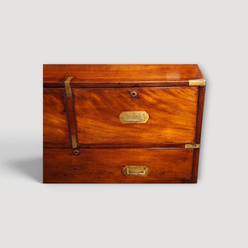 fig 9. A Victorian mahogany campaign chest featuring two short drawers over three long drawers with flush brass handles, brass corner brackets, and turned feet.