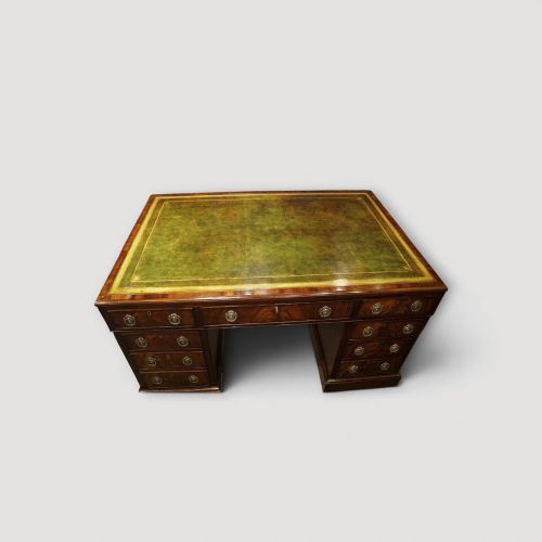 fig 4. A Victorian mahogany partners desk featuring a green leather writing surface, dual pedestals with drawers, and round brass handles.