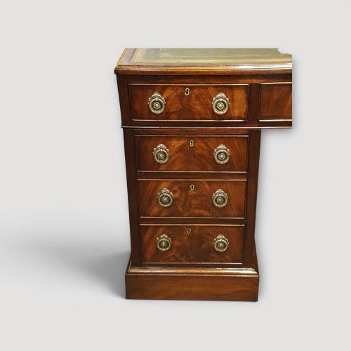 fig 5. A Victorian mahogany partners desk featuring a green leather writing surface, dual pedestals with drawers, and round brass handles.