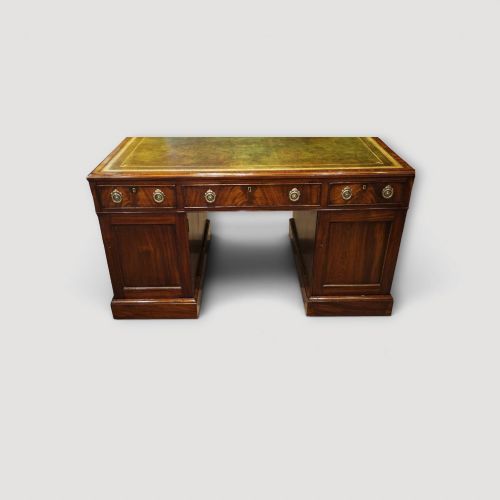 fig 8. A Victorian mahogany partners desk featuring a green leather writing surface, dual pedestals with drawers, and round brass handles.