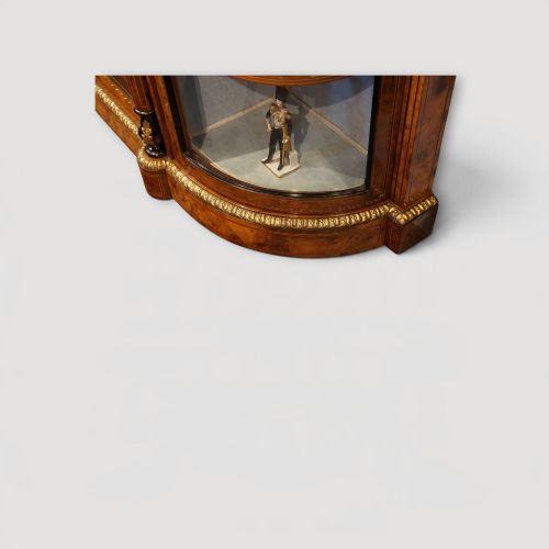 fig 3. A Victorian burr walnut credenza featuring a central marquetry inlaid door flanked by two curved glazed display side cabinets with gilt mounts.